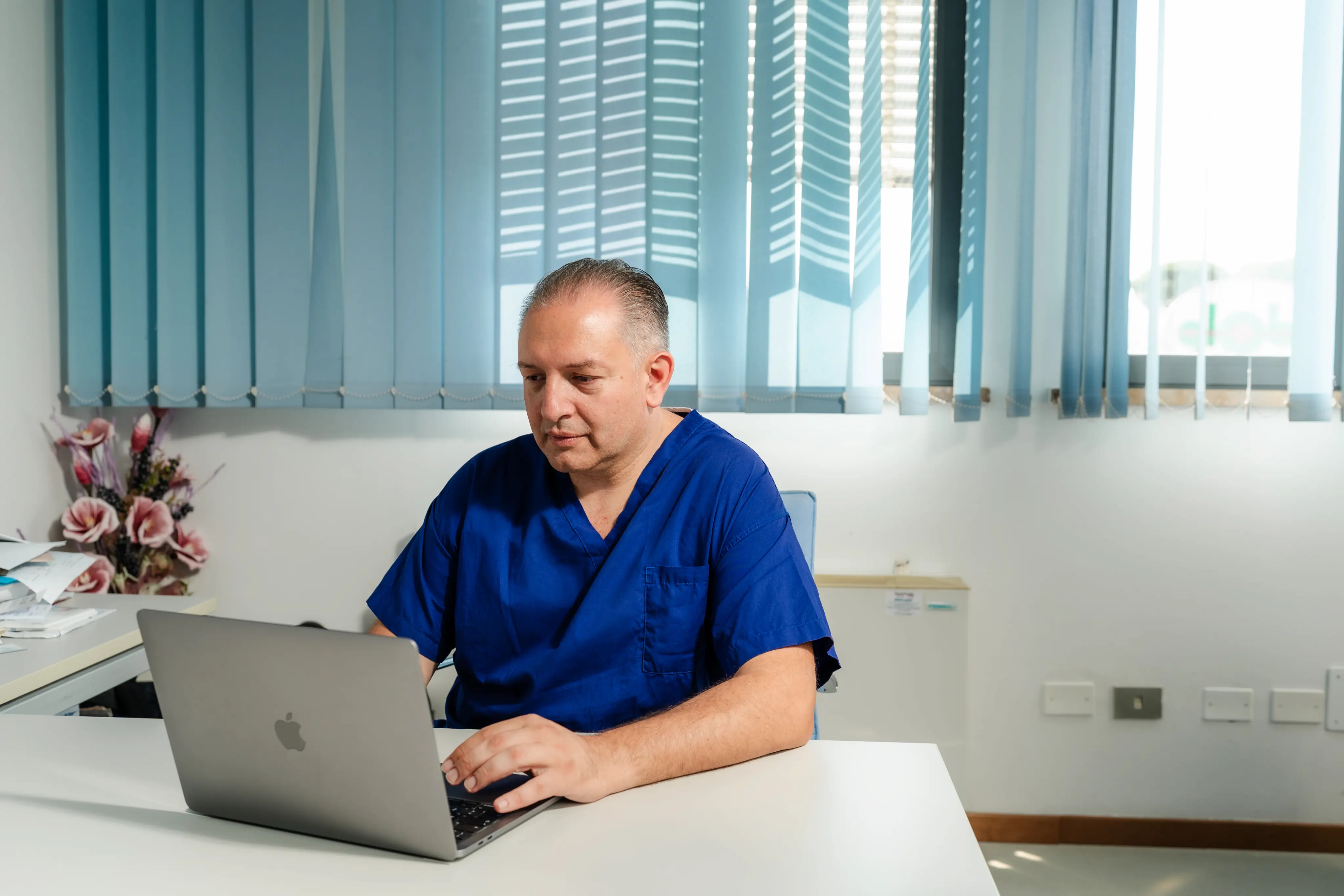 Il dottor Nicola Bigliazzi, ortopedico a Lucca e Livorno, nel suo studio medico al computer
